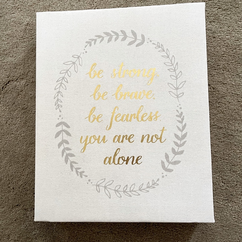 Fabric sign over wooden frame “be strong be brave be fearless you are not alone”